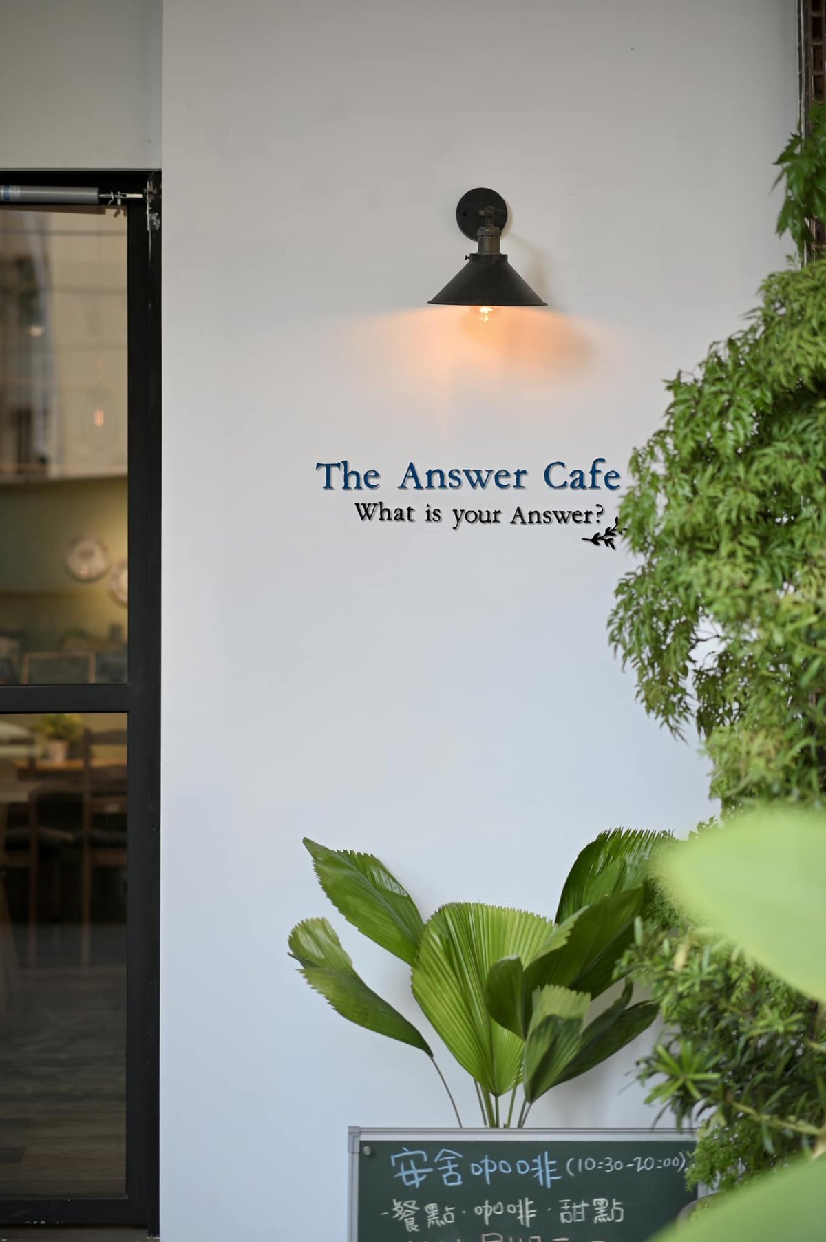 安舍咖啡店外牆「The Answer Cafe - What is your Answer?」字樣與門口的綠植