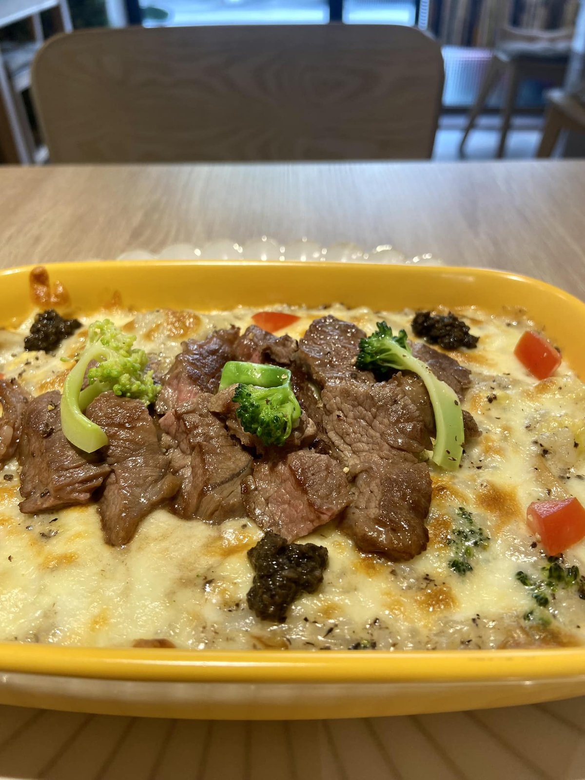 安舍招牌奶油松露牛小排焗烤燉飯：金黃焗烤起司鋪上厚切牛小排